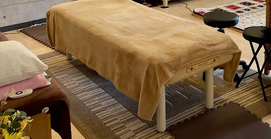整体サロンさくらの施術スペース。ベージュのカバーをかけた施術ベッド